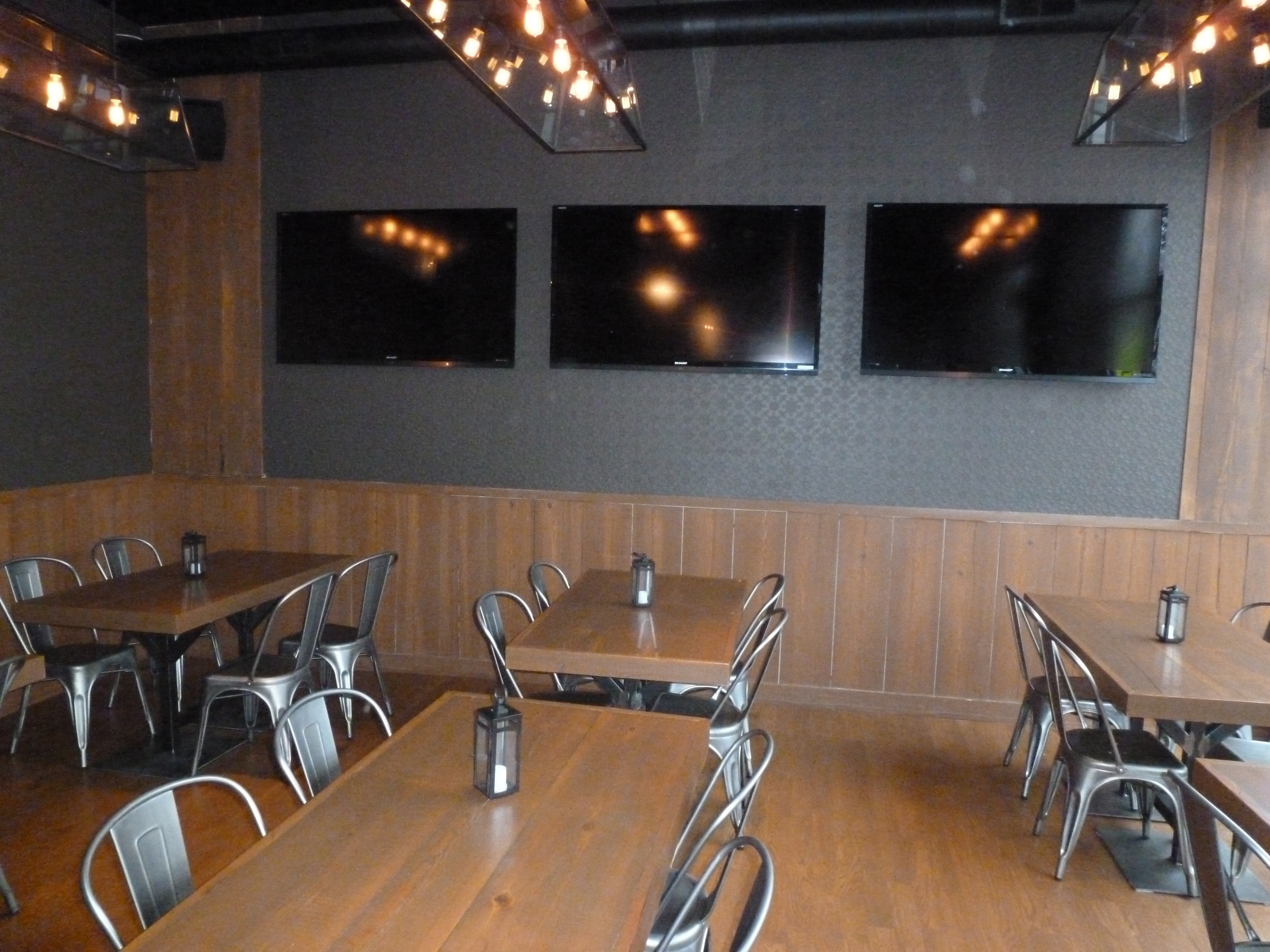 Blue Bar dining area with custom tables, steel stools, and warm wood finishes