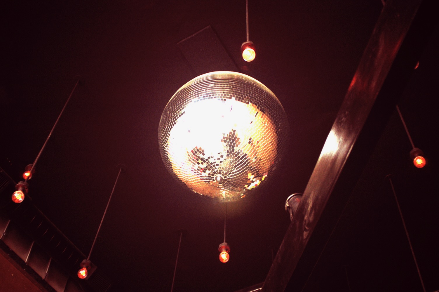 Disco ball and warm pendant lighting over the bar at Blue Bar