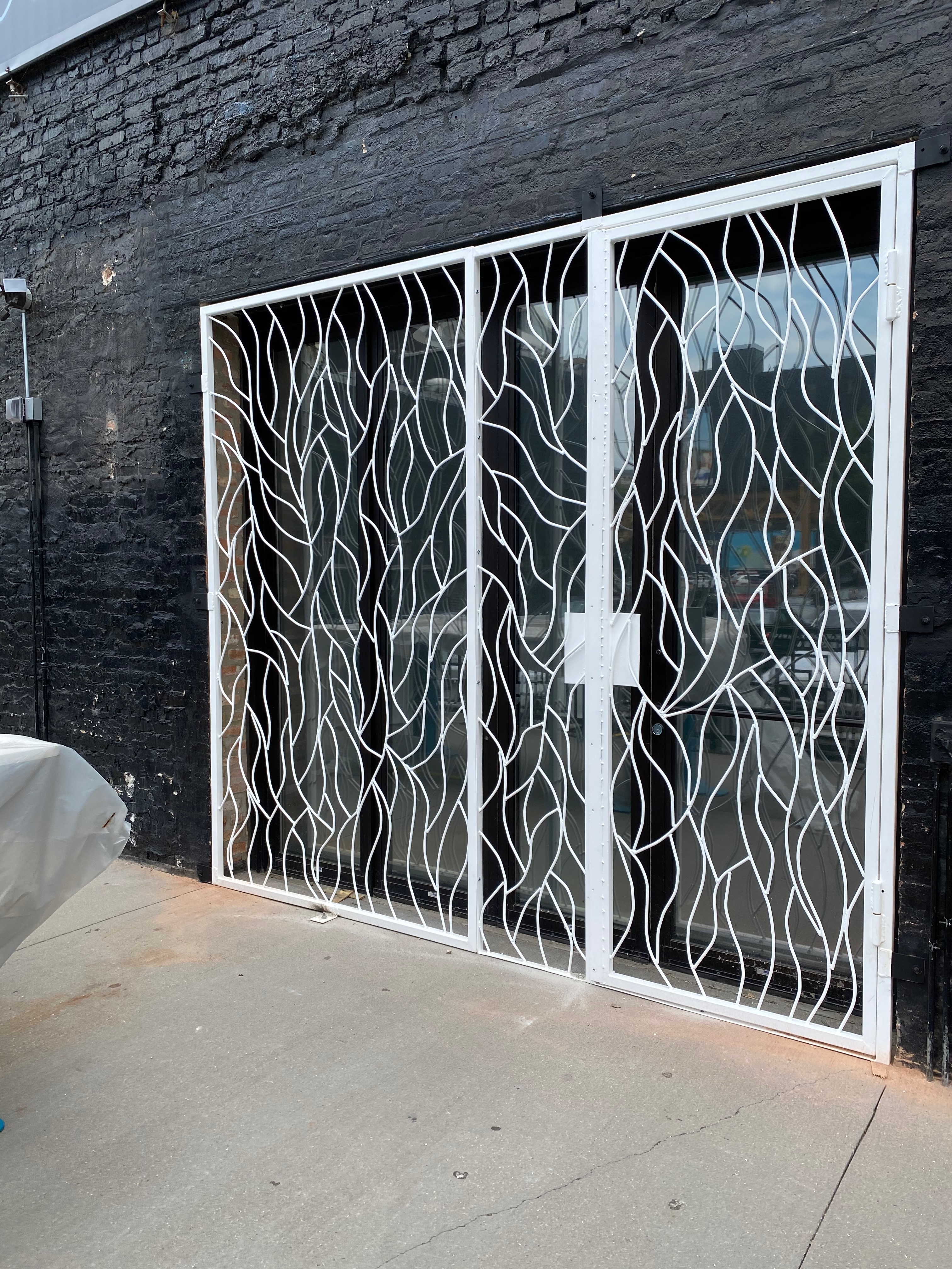 Stone-framed section of the Moca facade with vine-pattern metalwork